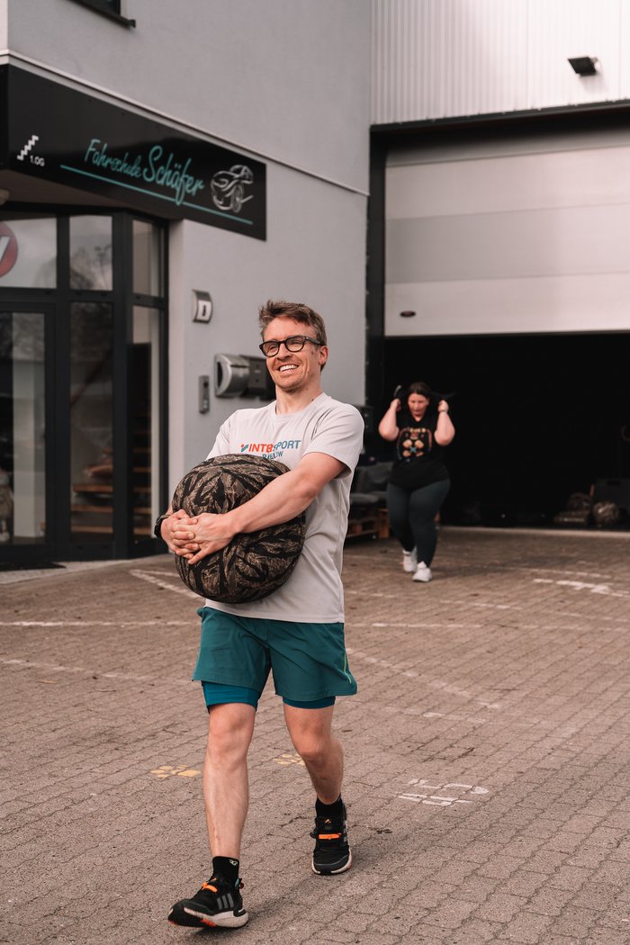 Mitglieder tragen gemeinsam Sandbags im Freien